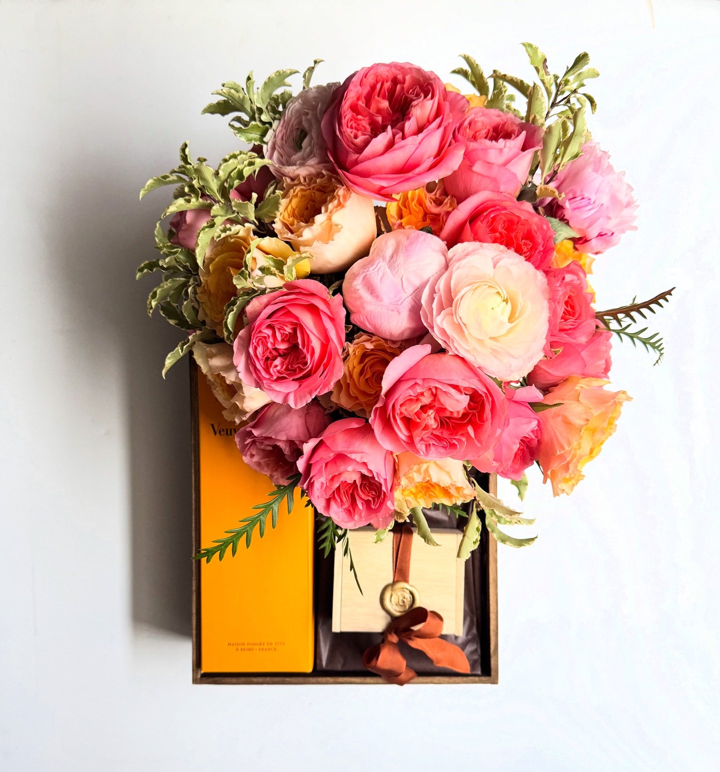 Alaric Flowers NYC Romantic arrangement of garden, long-stem roses, ranunculus & spray blooms in coral-pink, blush, peach & buttercup yellow hues.
