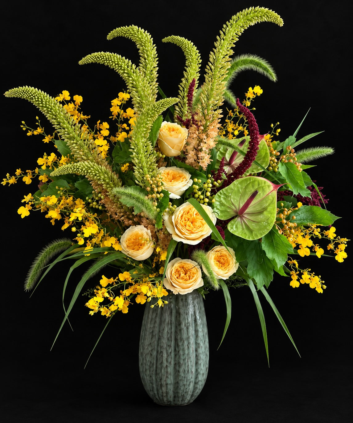 A vibrant flower arrangement in a ribbed gray-green ceramic vase, featuring yellow roses, yellow cluster flowers, green feathery stems, and green leaves, set against a solid black background.