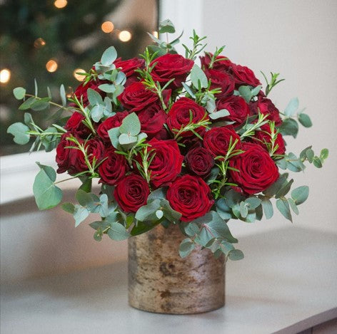 Alaric Flowers NYC Lush deep red bouquet of long-stemmed roses with eucalyptus and rosemary in an antiqued gold vase.